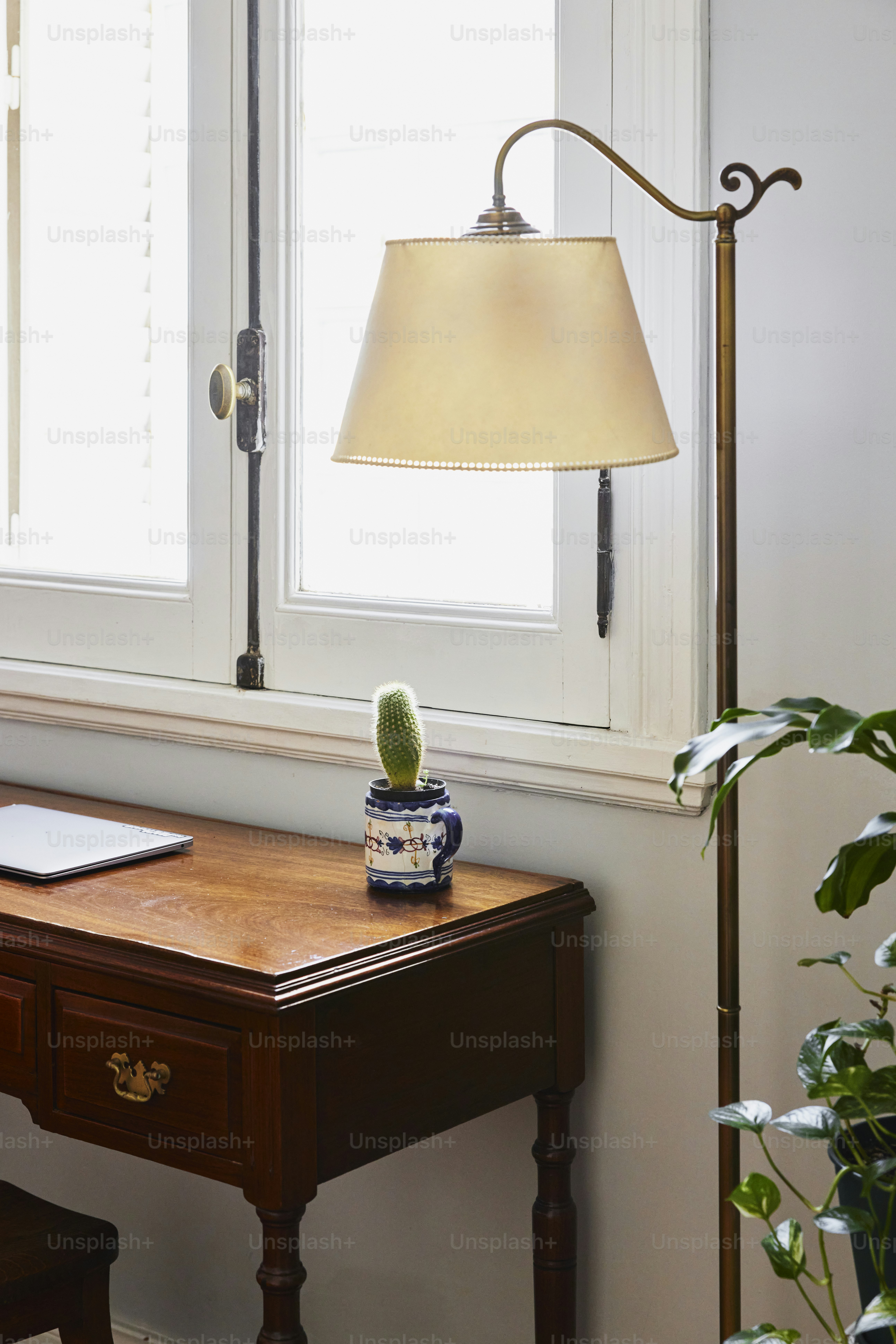 a desk with a lamp and a laptop on it