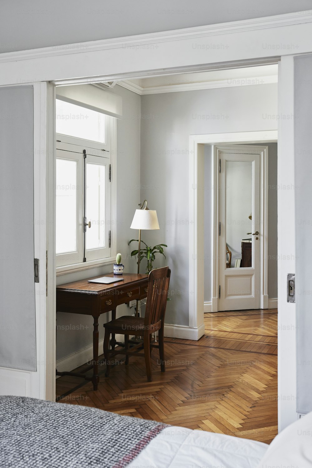 a bedroom with a bed, desk and mirror