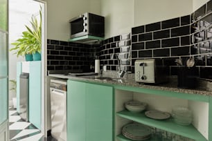 a kitchen with green cabinets and black and white tiles