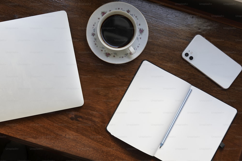 una tazza di caffè e un computer portatile su una scrivania