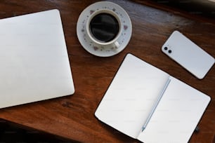 uma xícara de café e um laptop em uma mesa