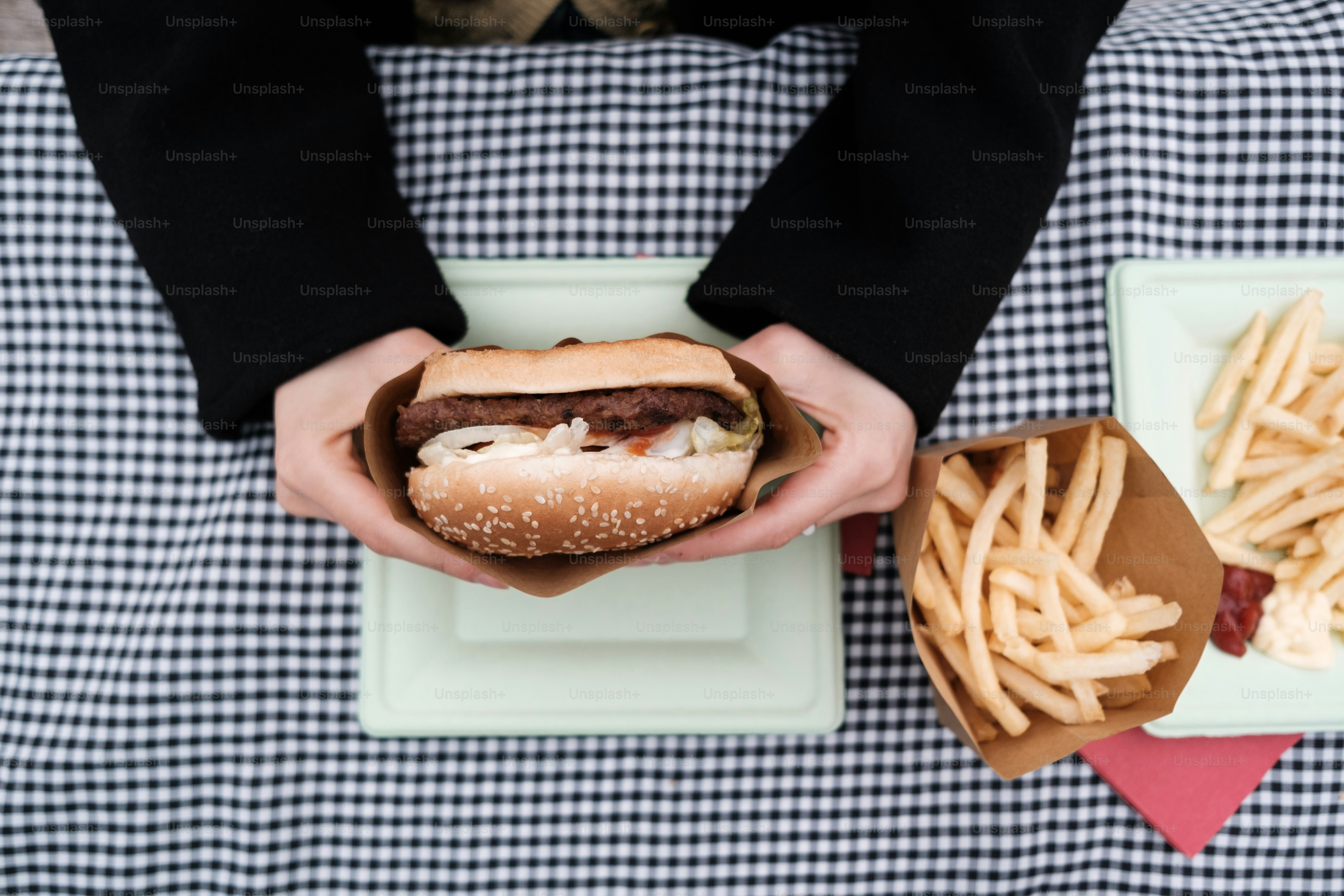 햄버거와 감자튀김을 들고 있는 사람