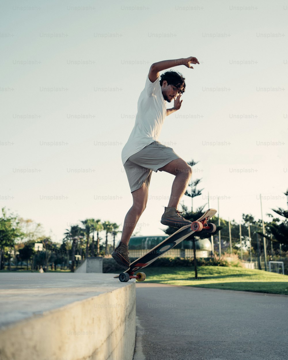 ein mann, der auf einem skateboard an der seite einer zementmauer hinunterfährt