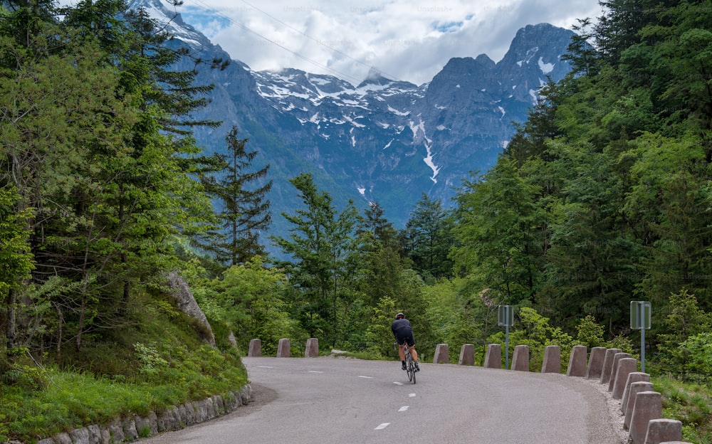 a bicyclist rides down a mountain road