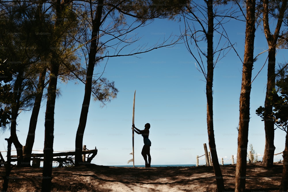 Una persona sosteniendo una espada en medio de un bosque