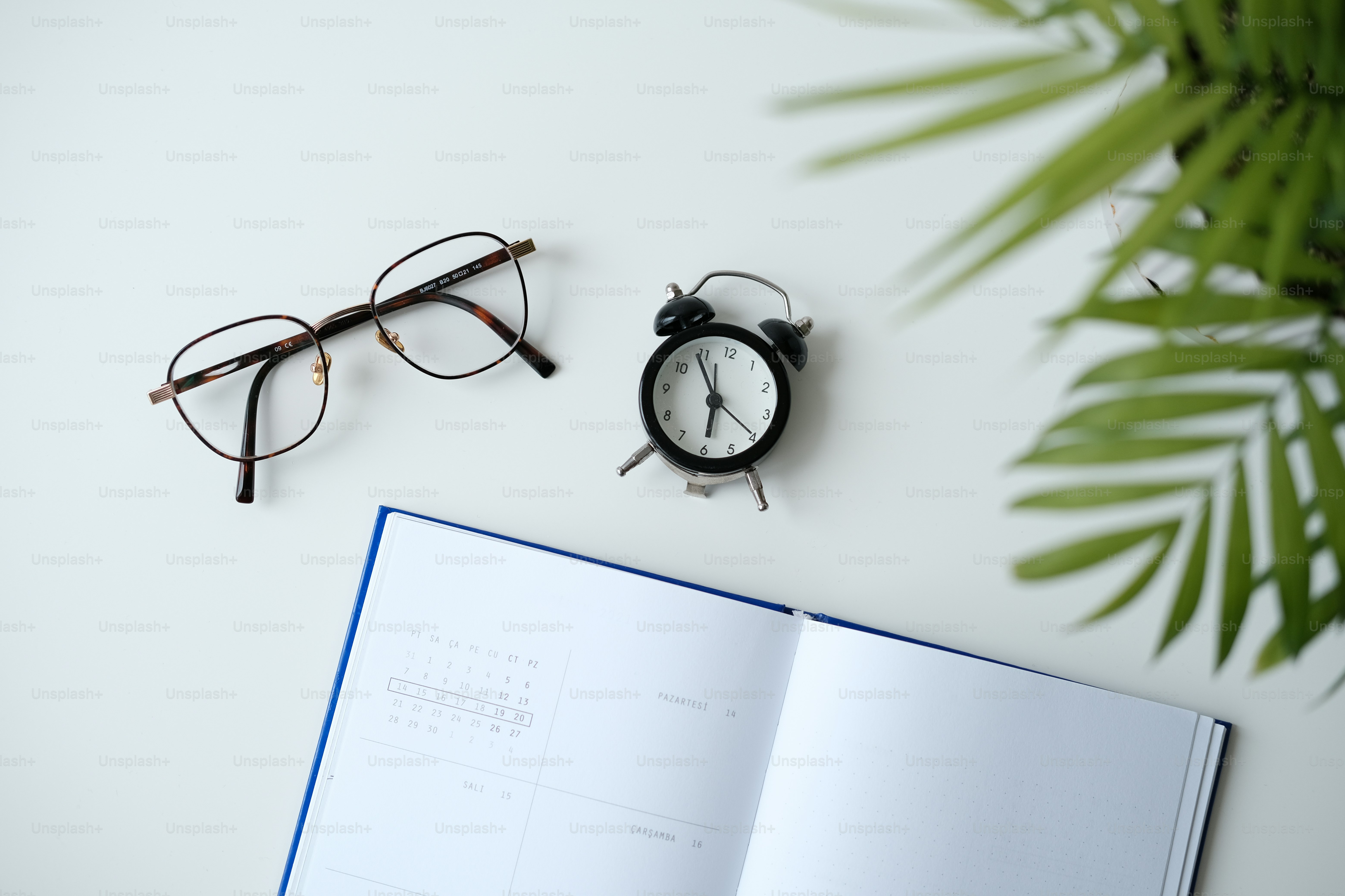 Un libro abierto con gafas y un reloj encima