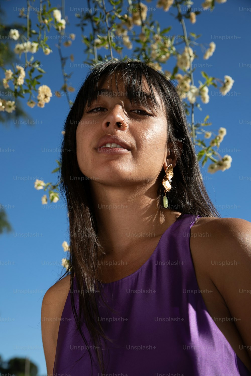 a woman standing under a tree with white flowers