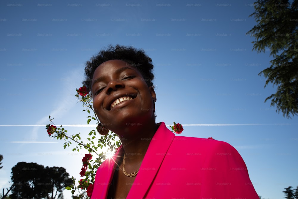 Une femme en veste rose sourit à la caméra