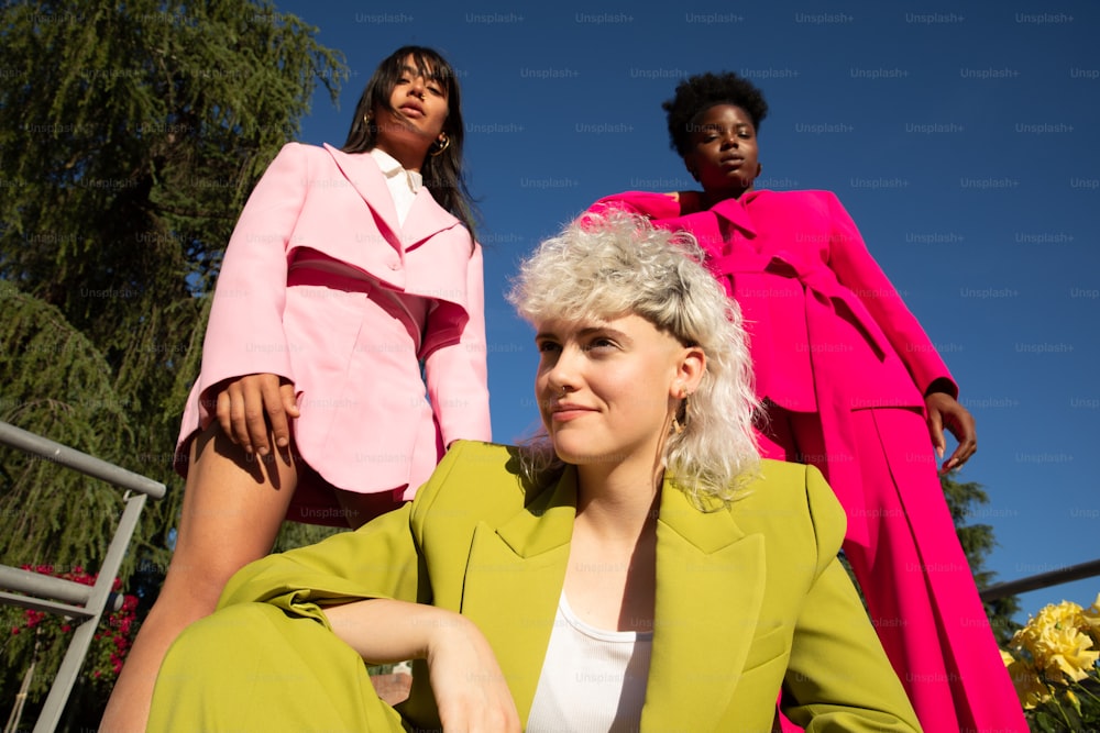 two women in pink and green outfits posing for a picture