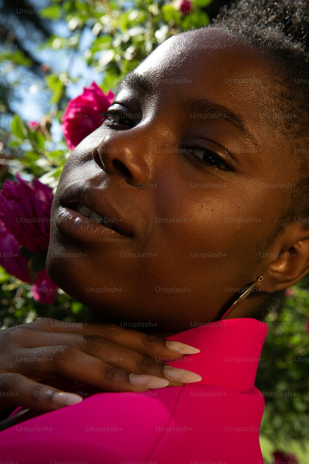 a close up of a person with flowers in the background