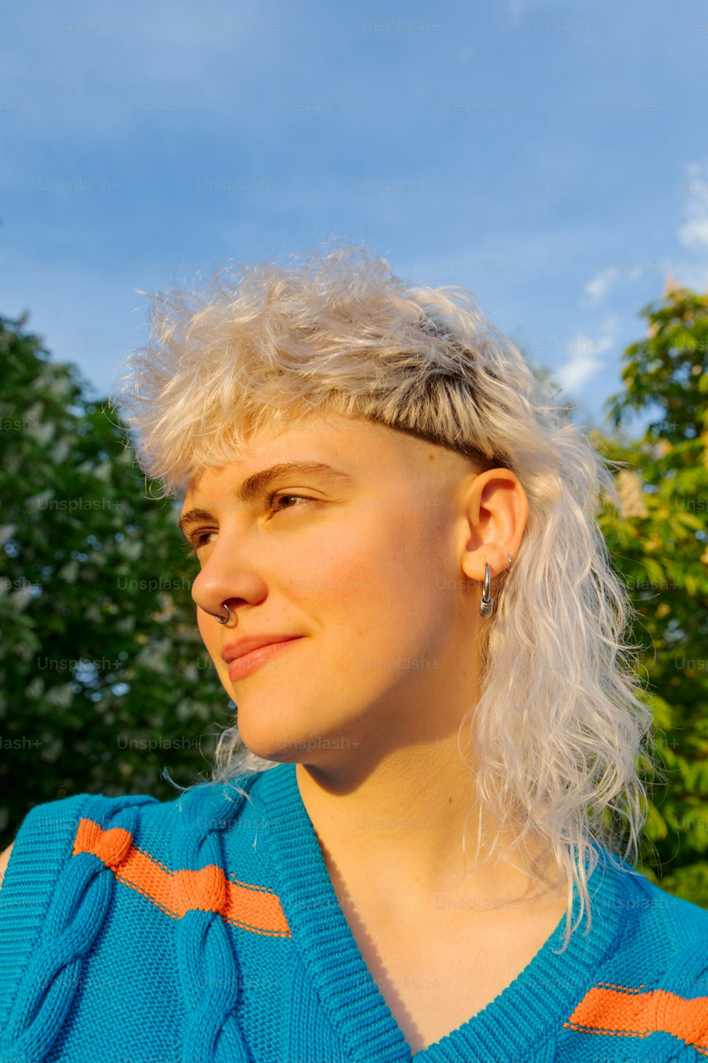 a woman with white hair wearing a blue sweater