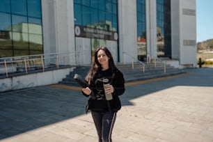 a woman holding a skateboard in front of a building