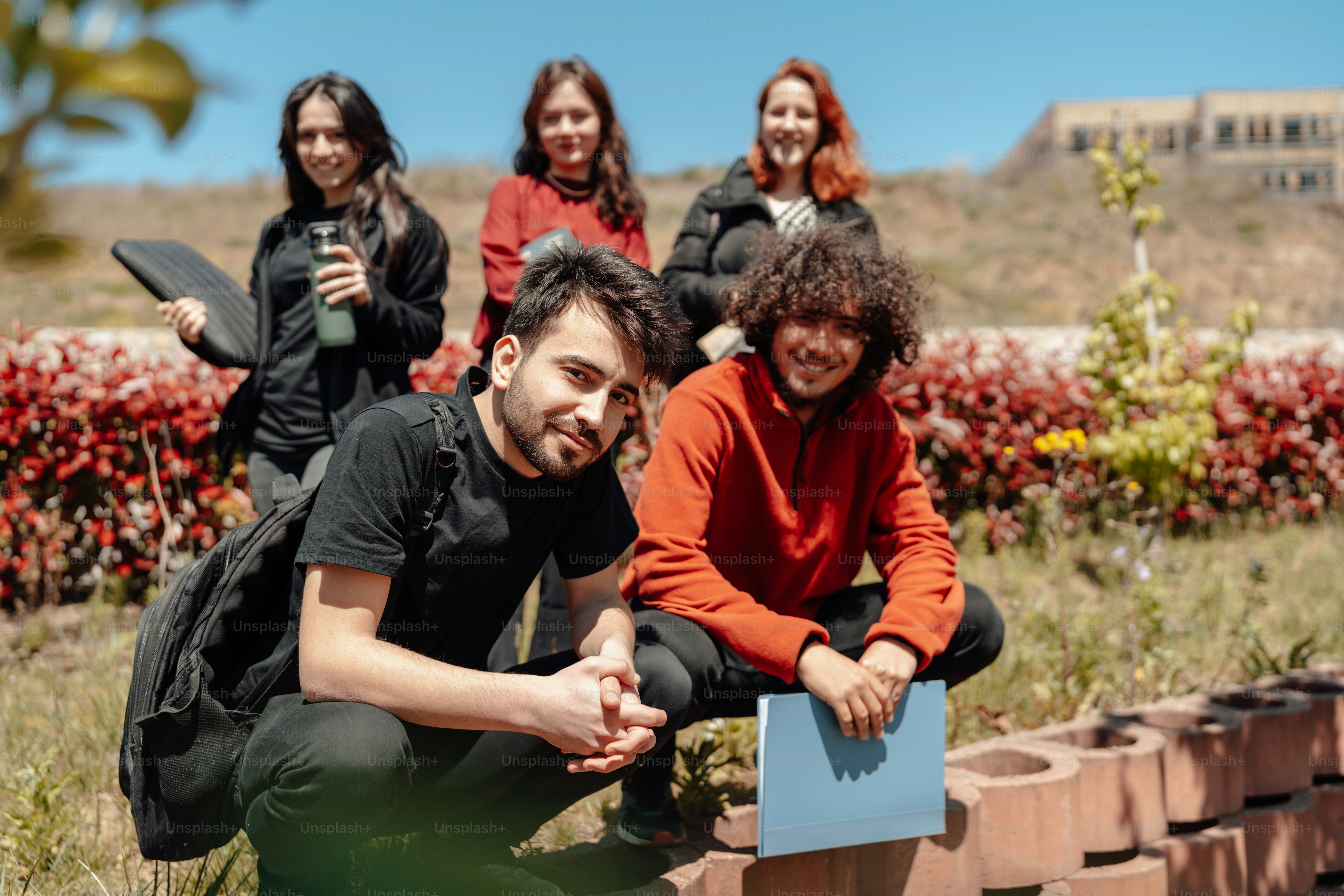 a group of people standing around a brick wall