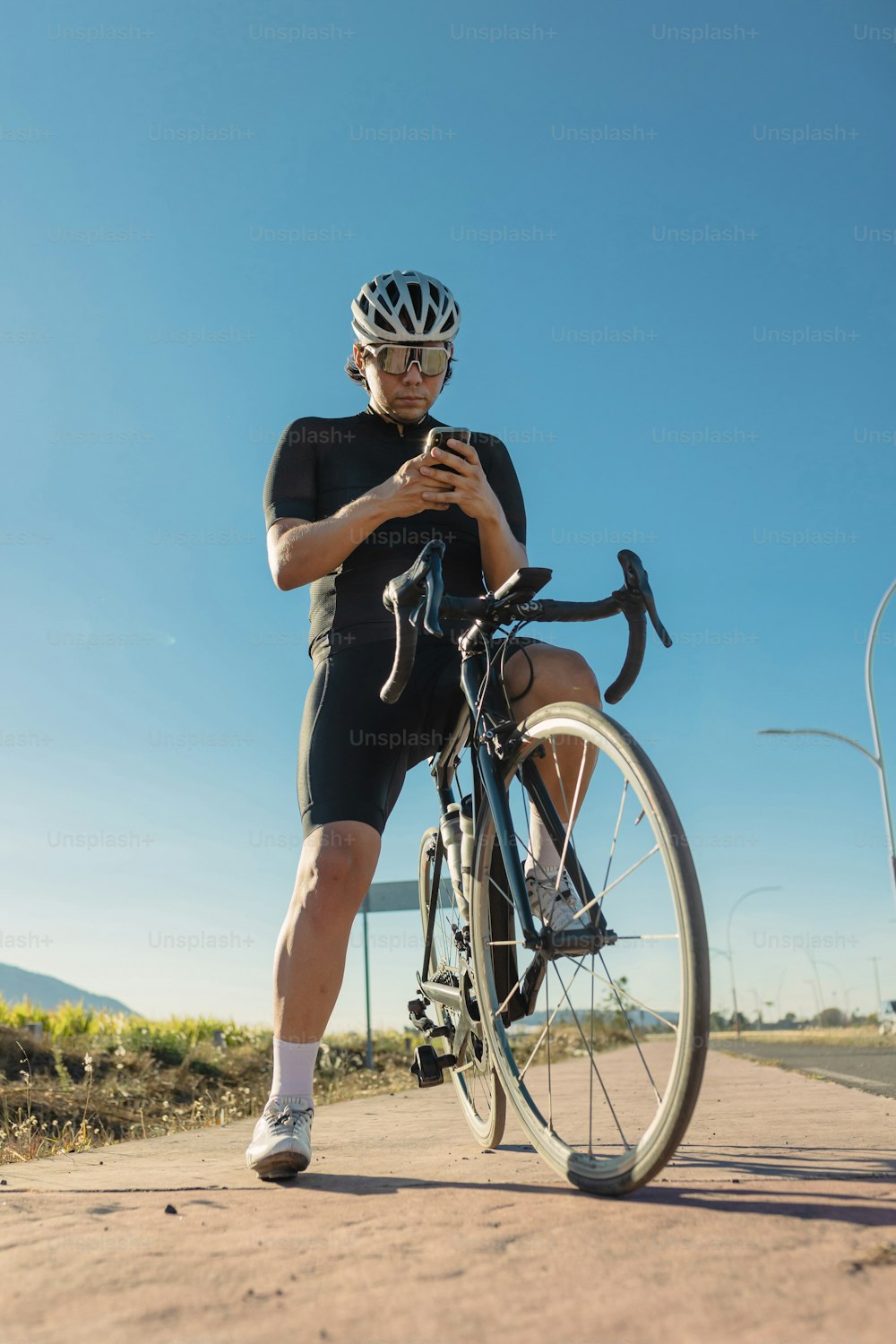 um homem em uma bicicleta olhando para seu celular