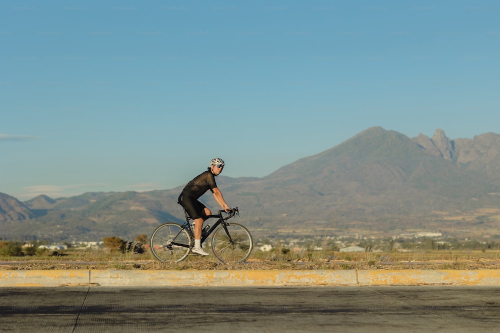 um homem andando de bicicleta no meio de uma estrada