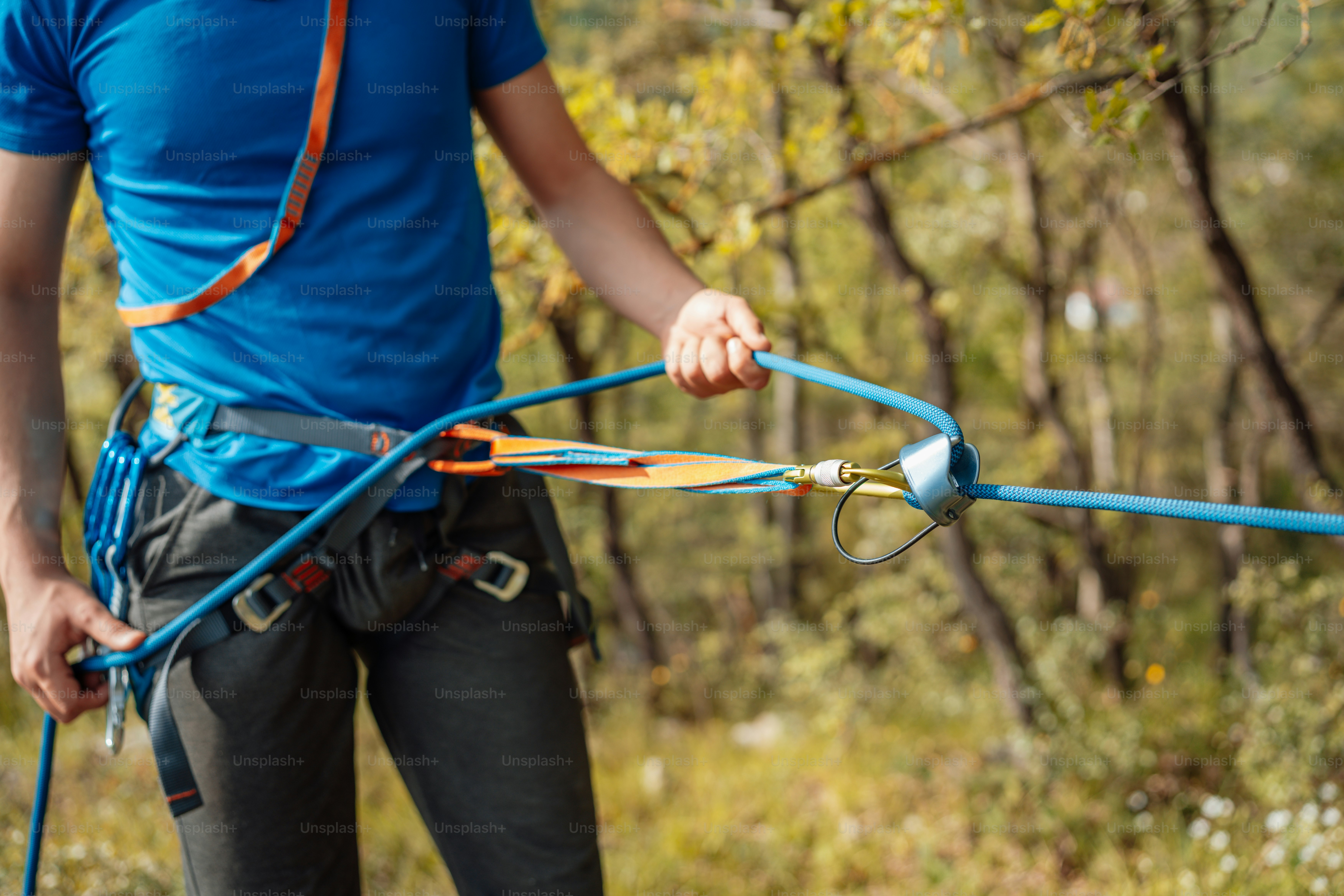 a man in a blue shirt is holding a rope