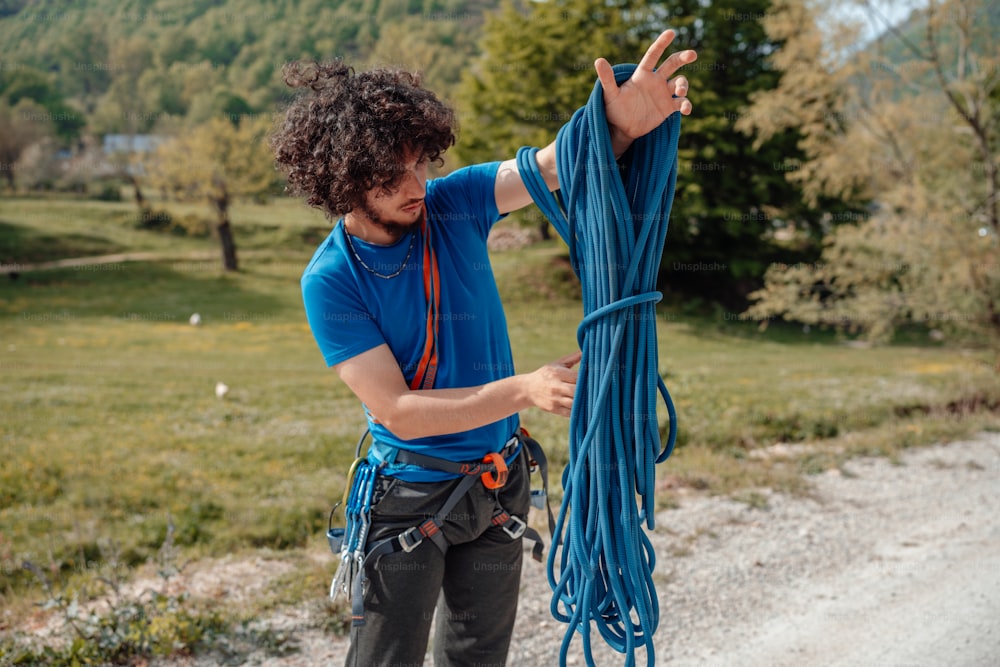 a man holding a blue rope on the side of a road