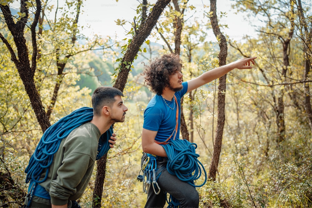a man pointing at another man in the woods