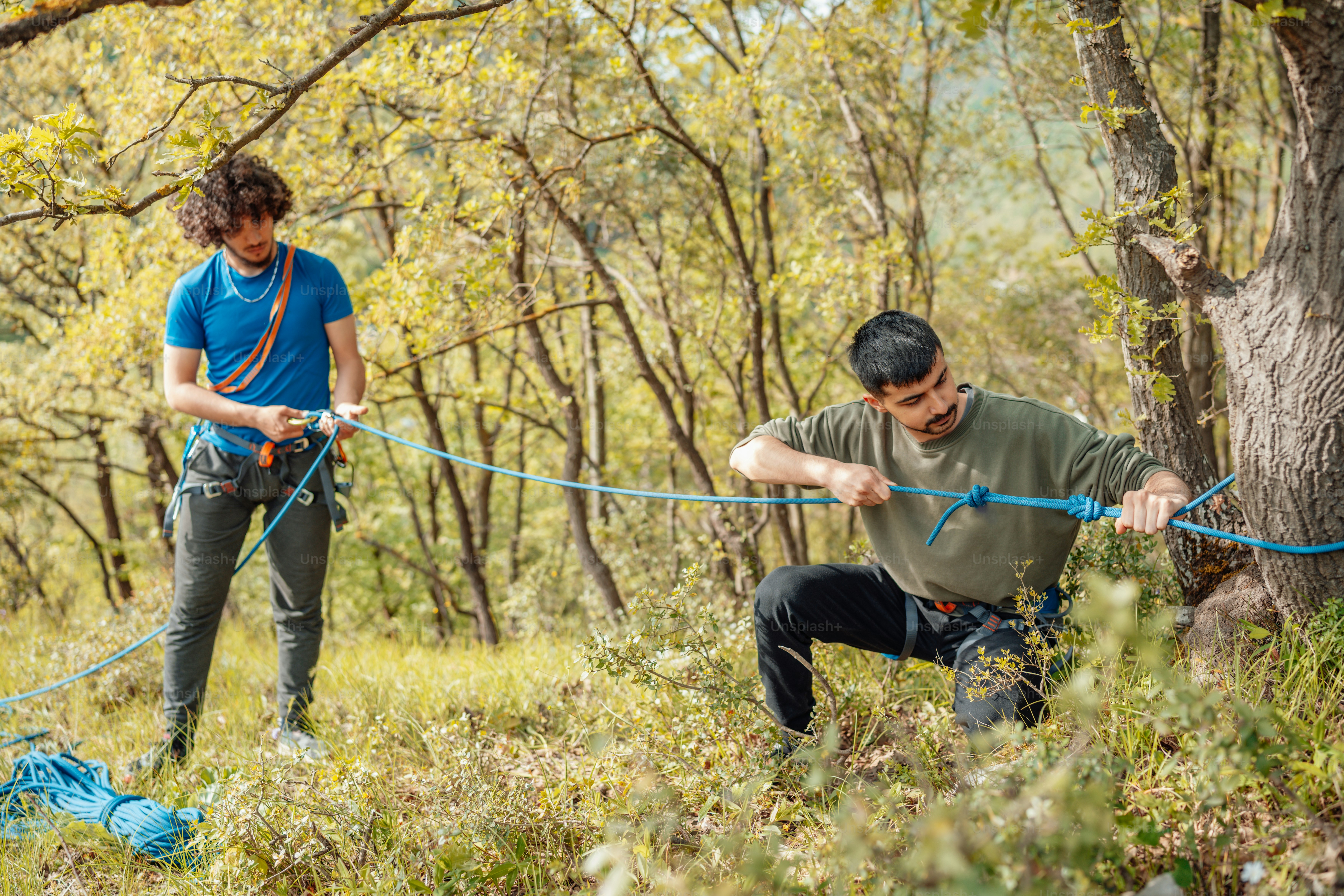 A man and woman pulling a rope through a forest photo – Sport Image on ...