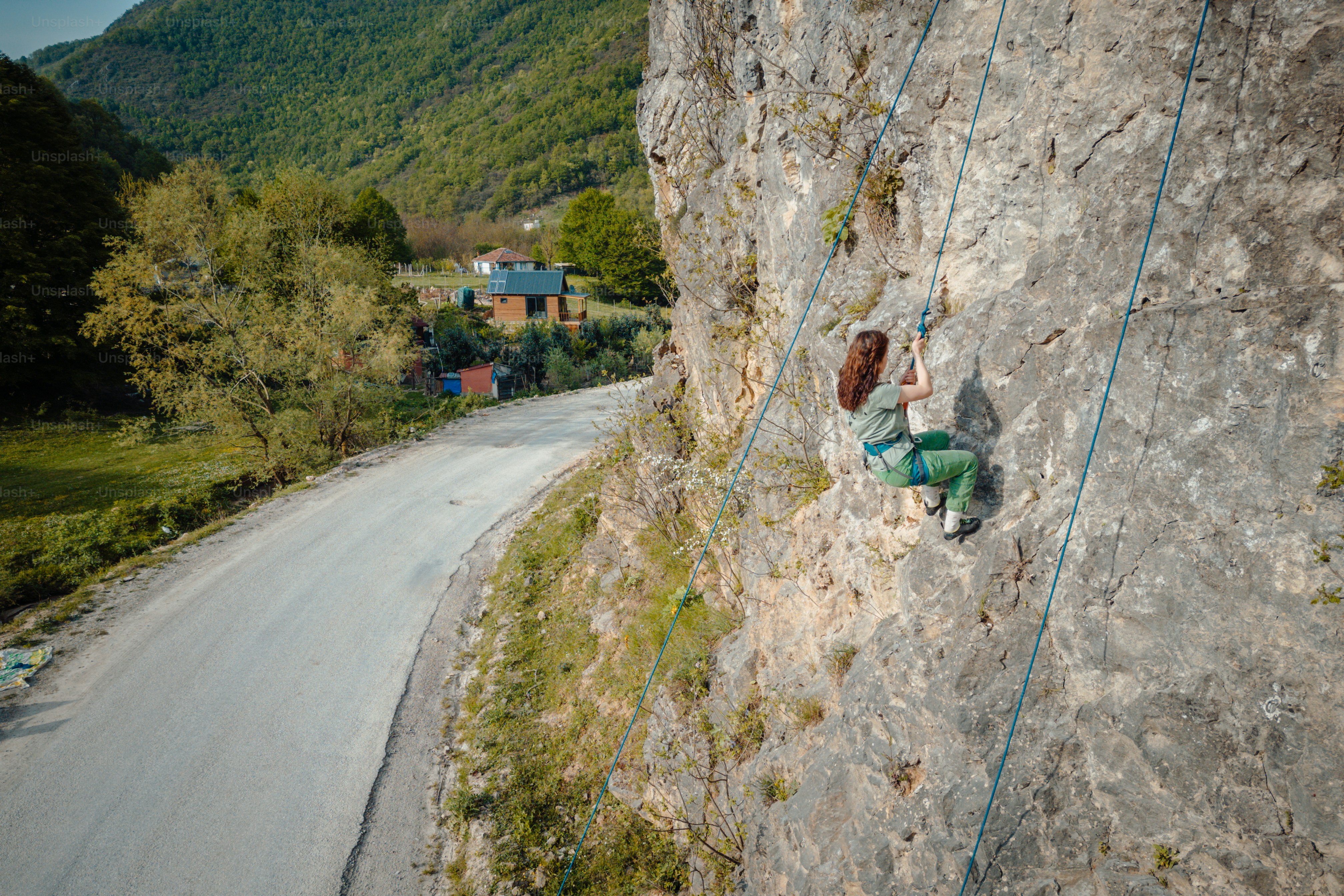 a woman climbing up the side of a mountain