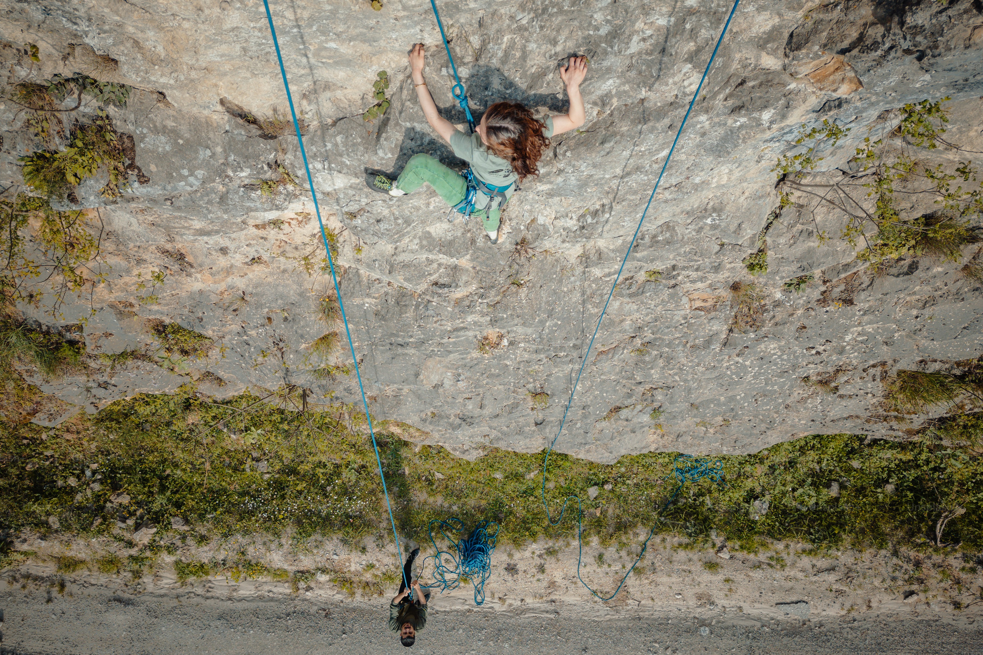 a woman climbing up the side of a mountain