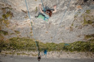 Una mujer trepando por la ladera de una montaña