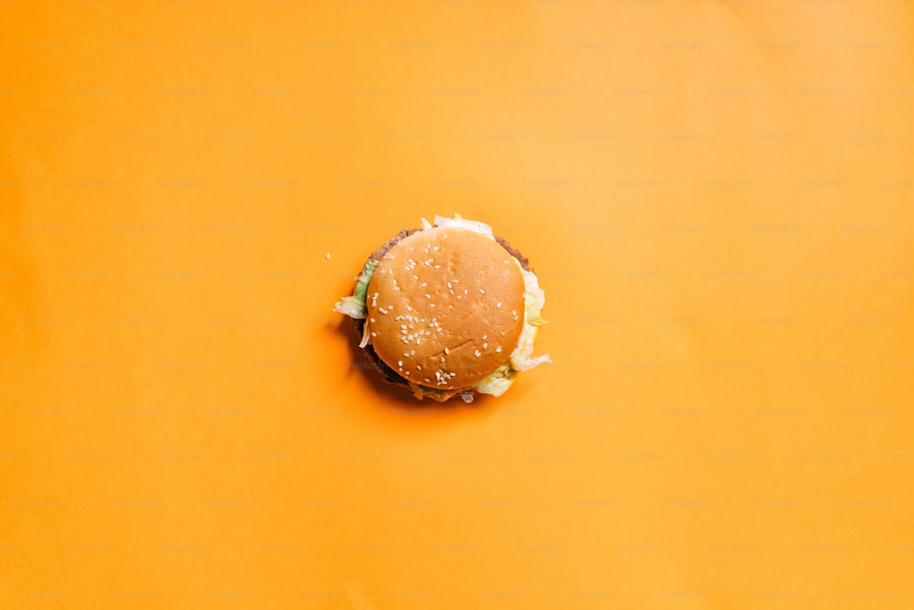 a cheeseburger on a yellow background with sprinkles