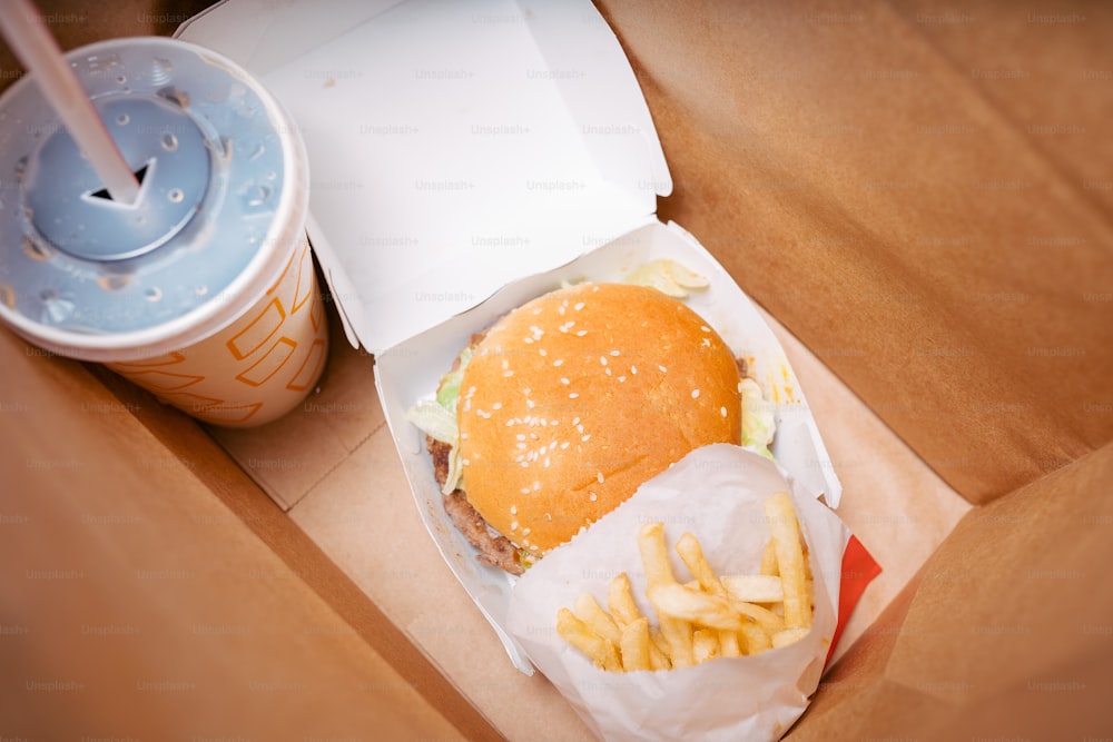 Gros plan d’un hamburger et de frites dans une boîte