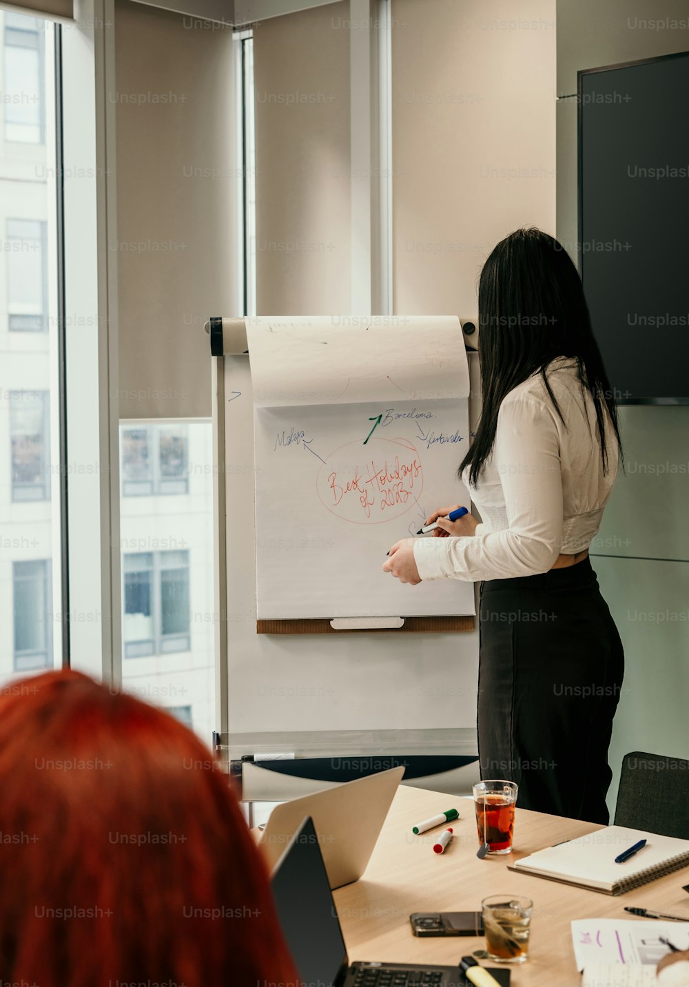 a woman standing in front of a whiteboard with writing on it