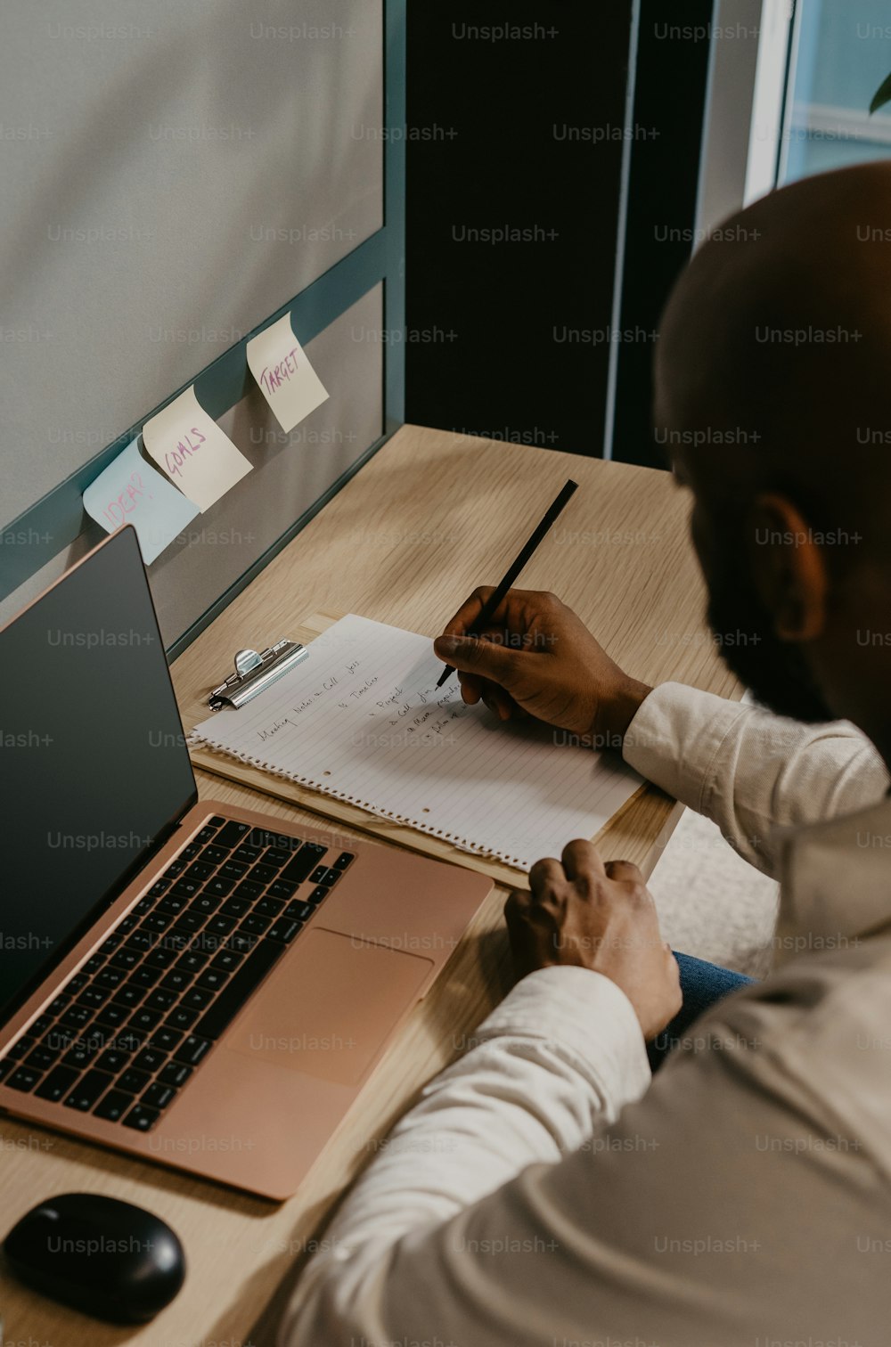 a man sitting at a desk writing on a piece of paper