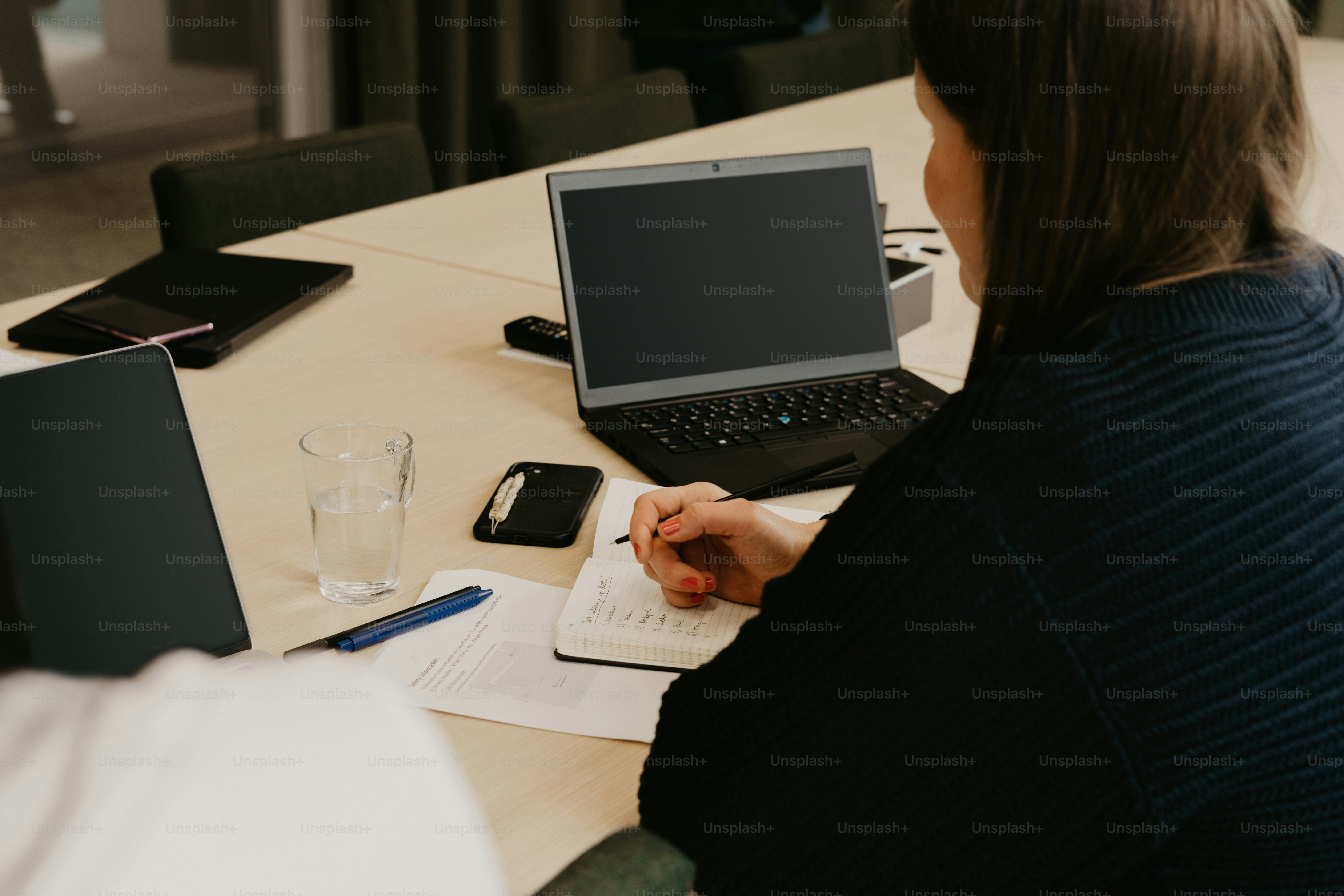 une femme assise à une table avec un ordinateur portable