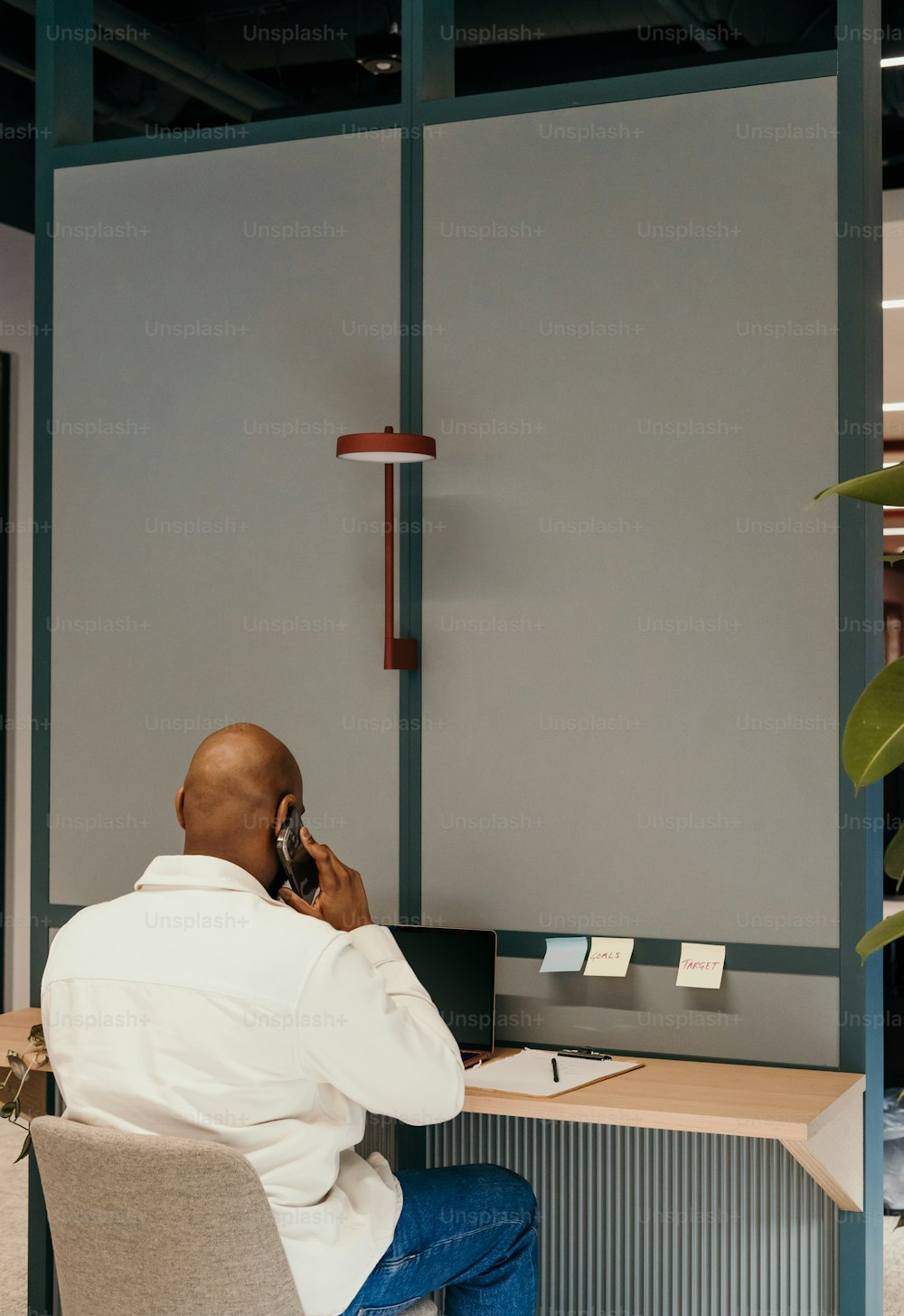 Un homme assis à un bureau parlant au téléphone portable