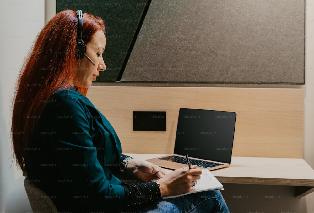 a woman sitting at a desk with a laptop