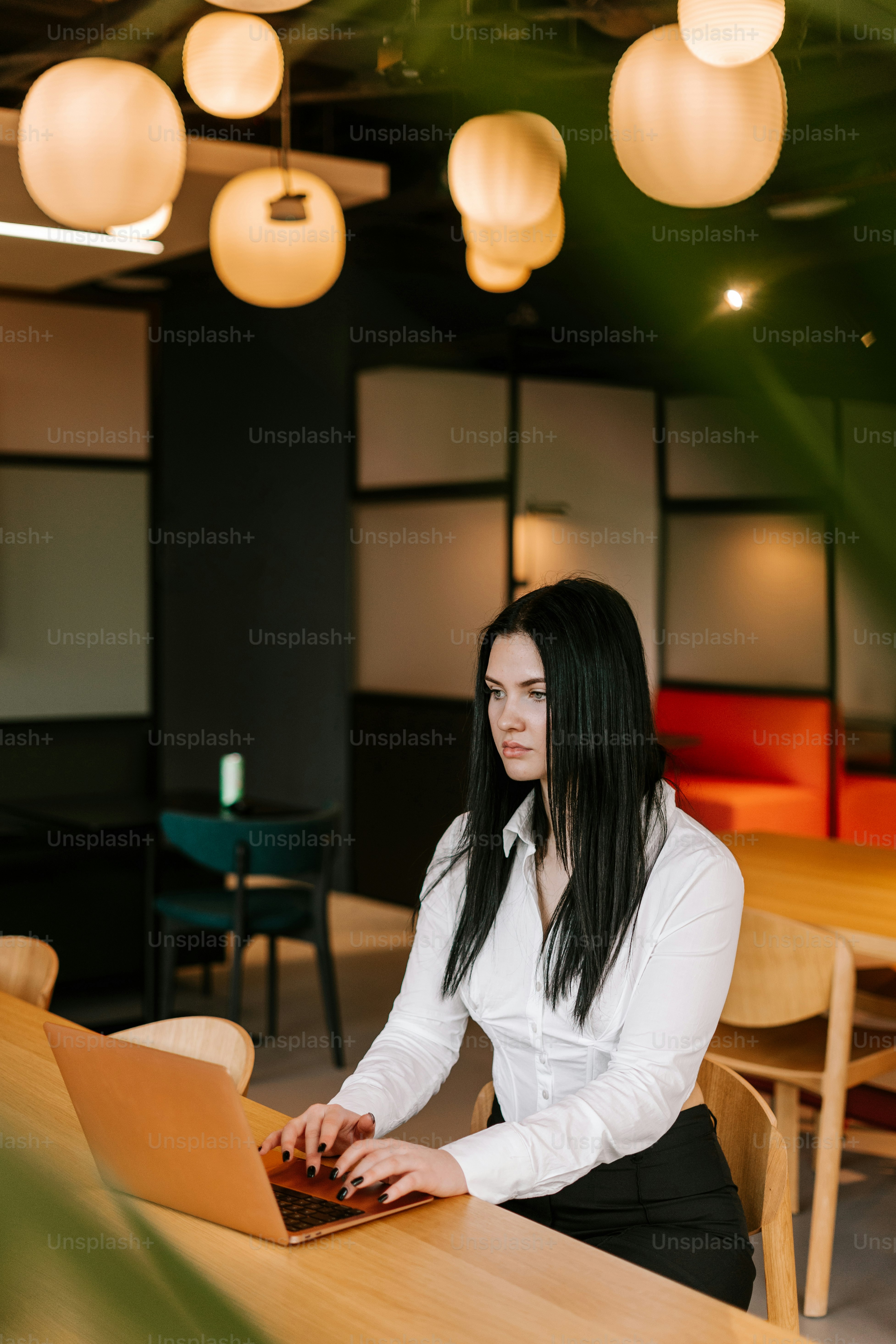 Eine Frau, die mit einem Laptop an einem Tisch sitzt