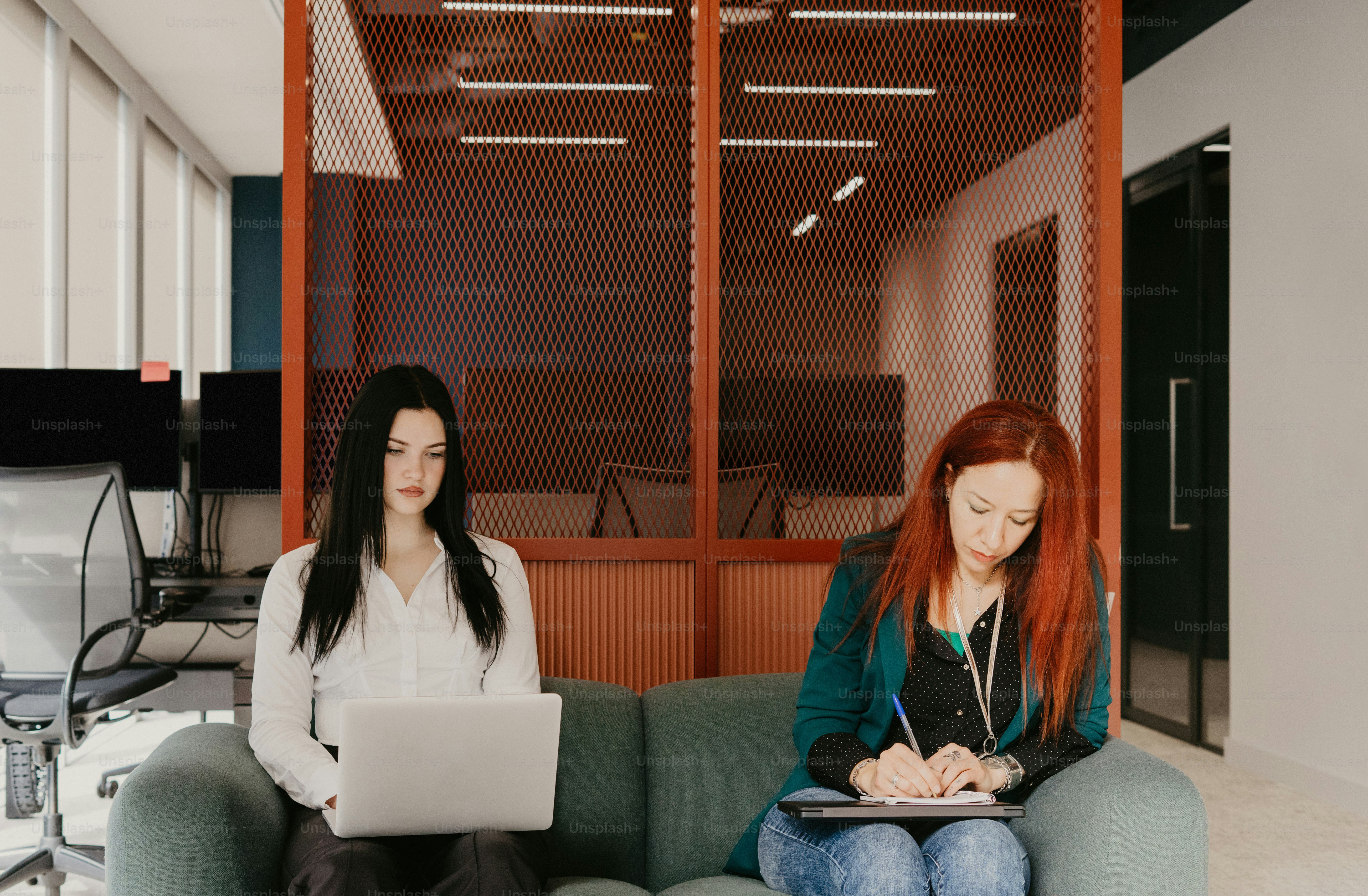 zwei frauen, sitzen, auf, a, couch, gebrauchend, laptops