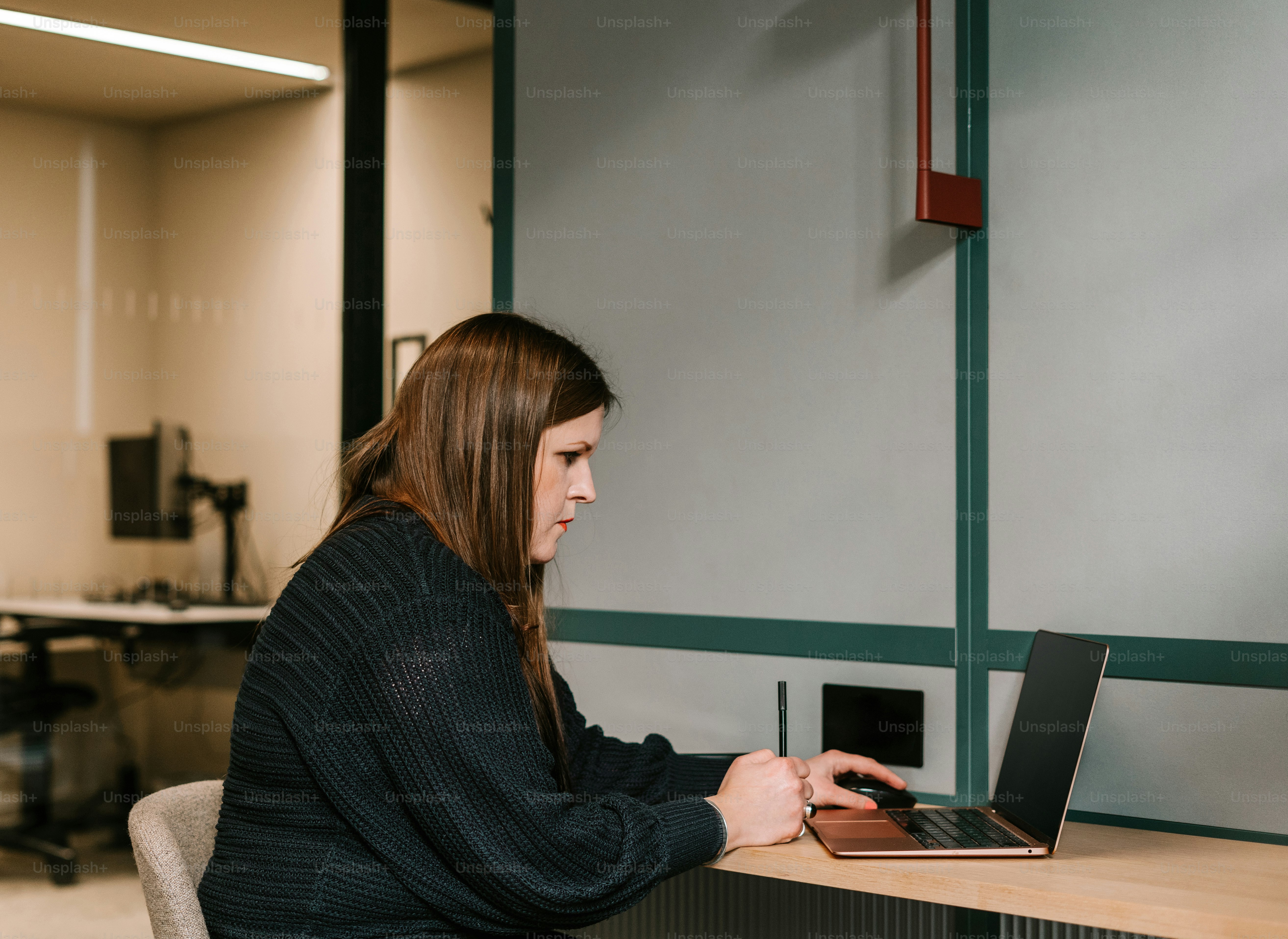 Una mujer sentada en un escritorio usando una computadora portátil