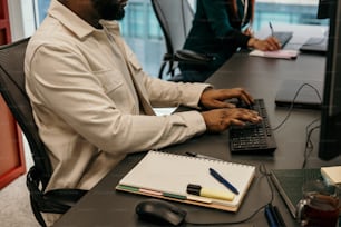 a man sitting at a desk using a laptop computer