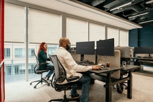 a man and woman sitting at a desk in an office