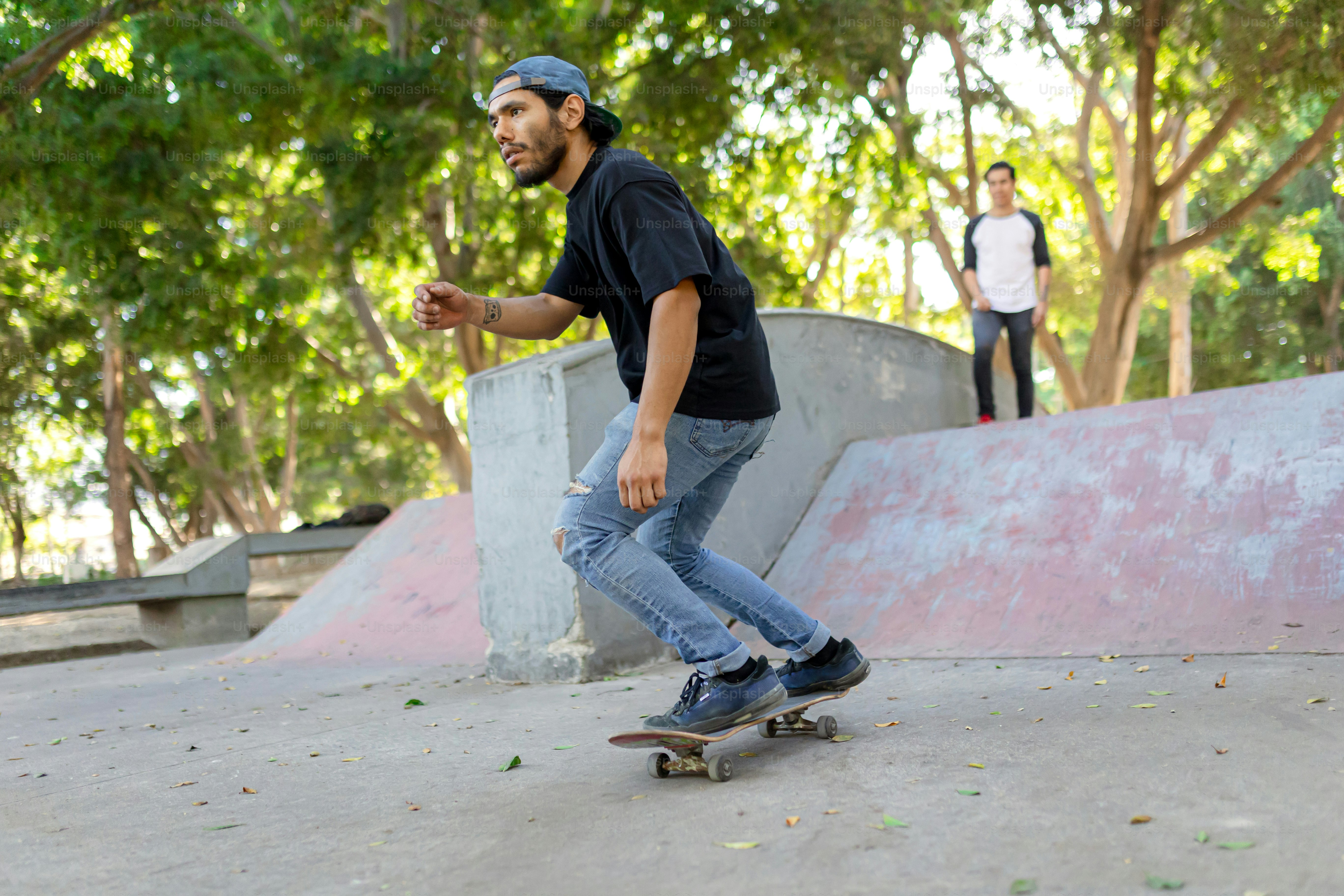 A man riding a skateboard down the side of a ramp photo – Sporting ...