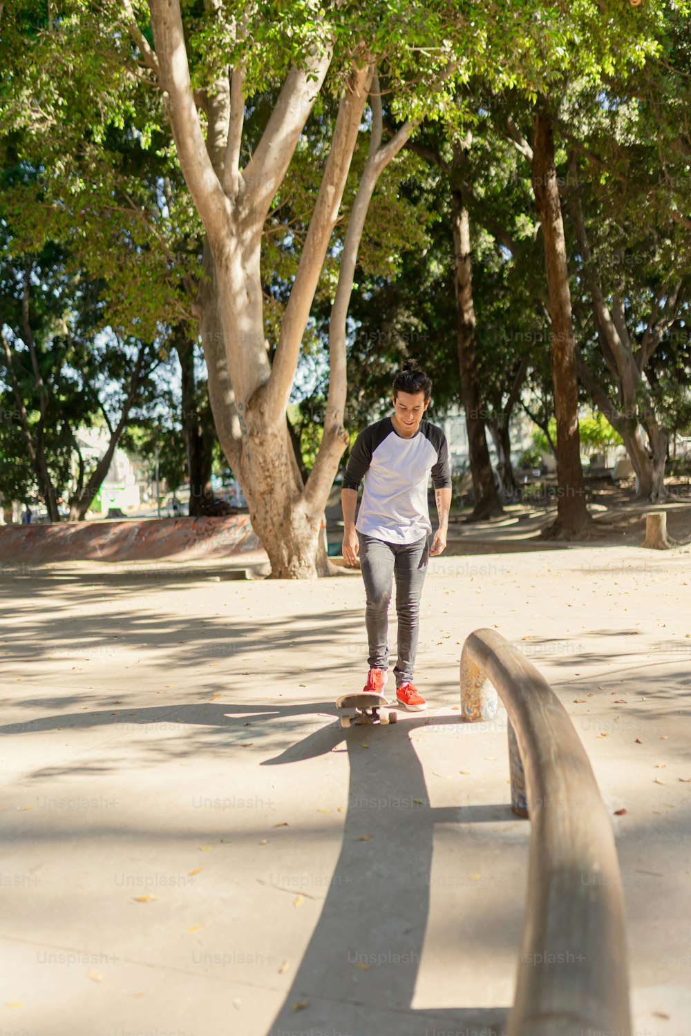 a young man riding a skateboard down a sidewalk