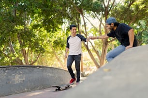 Un uomo che cavalca uno skateboard accanto a un altro uomo su uno skateboard