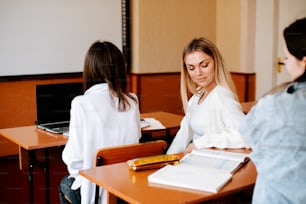 two women sitting at desks in a classroom