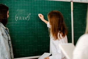 a woman writing on a blackboard with a ruler