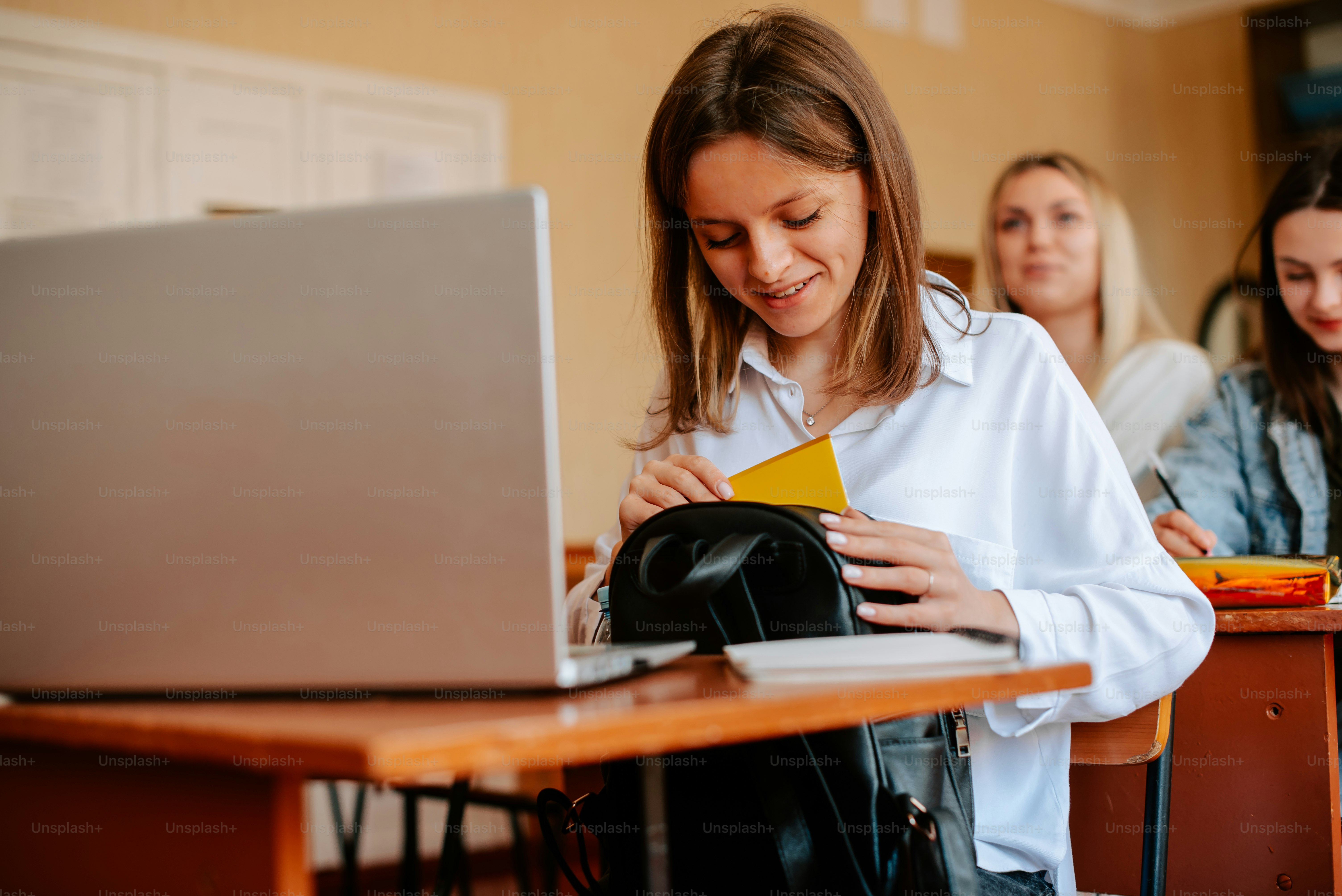 Dua gadis sedang duduk di meja dengan laptop