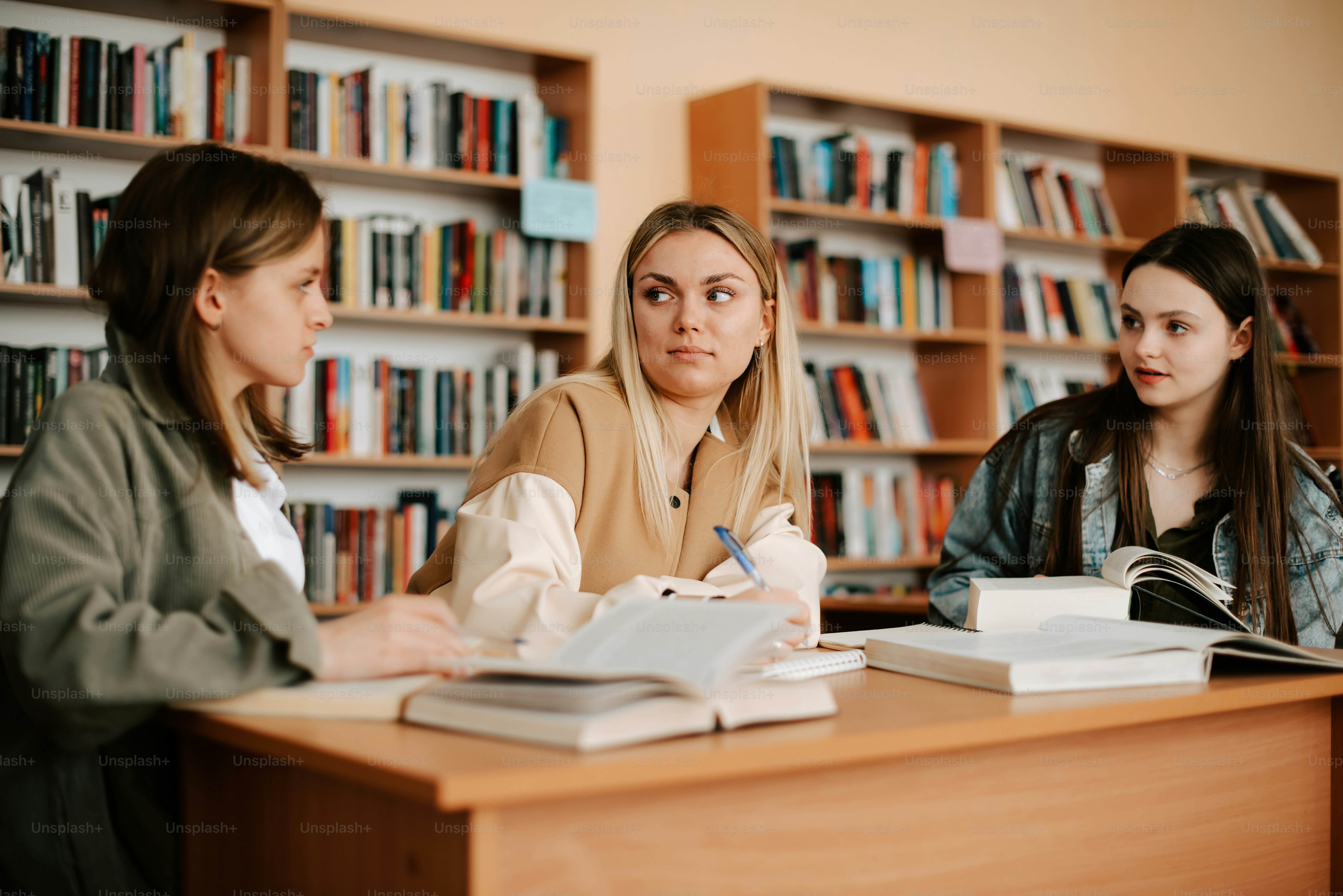 three women sitting at a table in a library