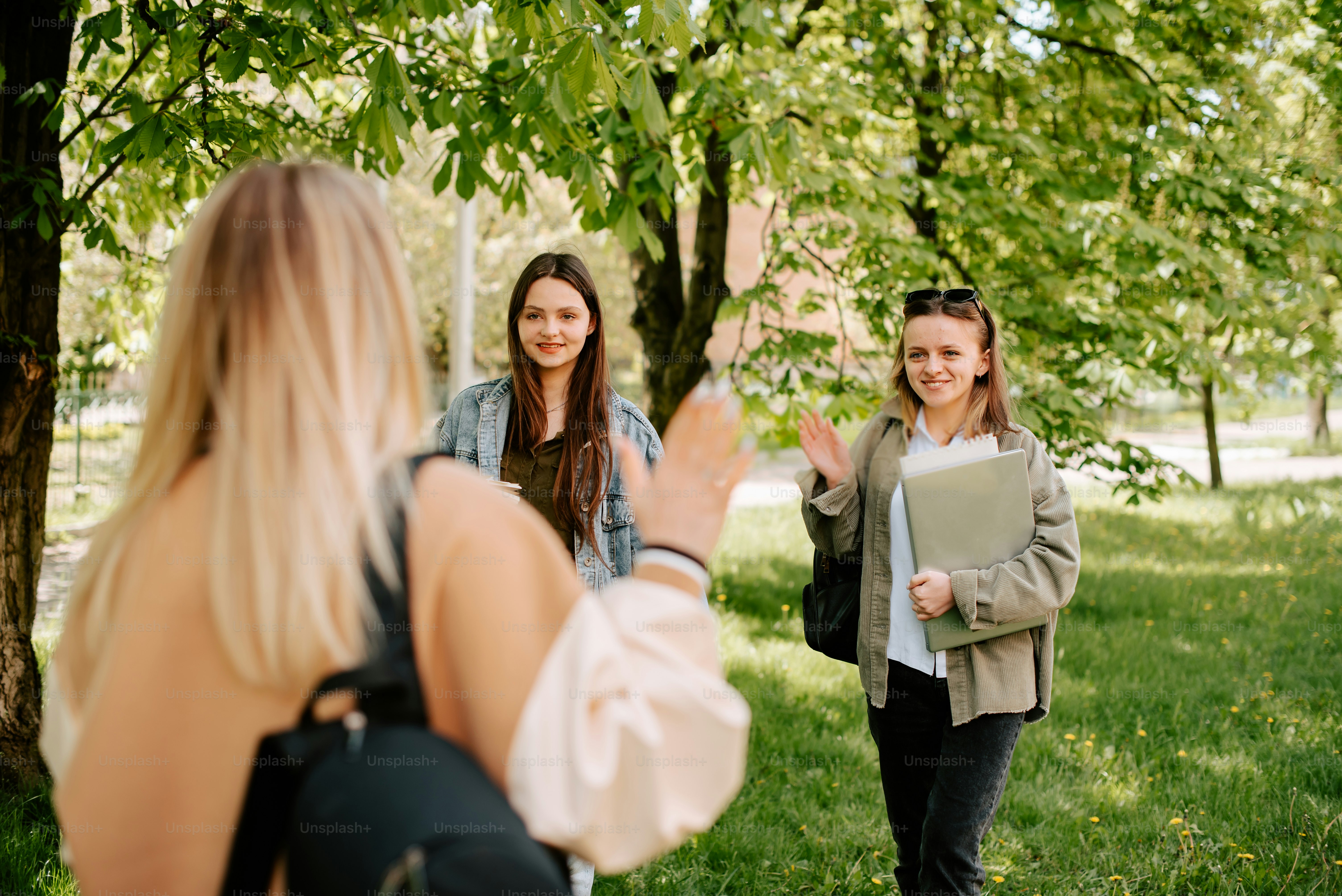 duas mulheres caminhando por um parque com árvores ao fundo