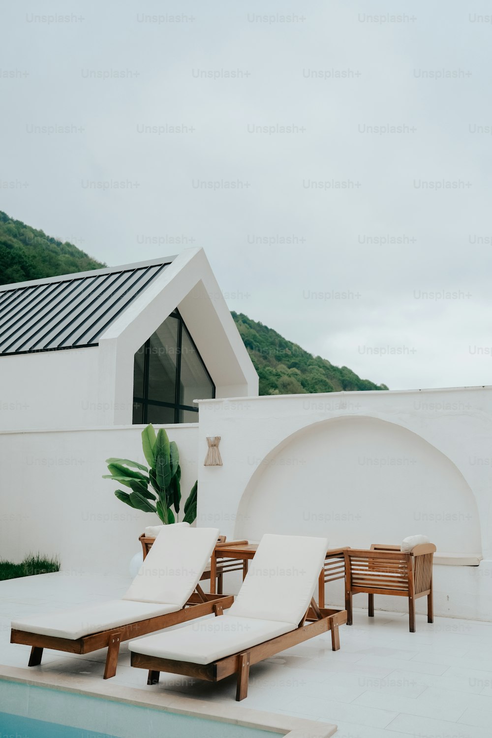 a couple of lounge chairs sitting next to a swimming pool