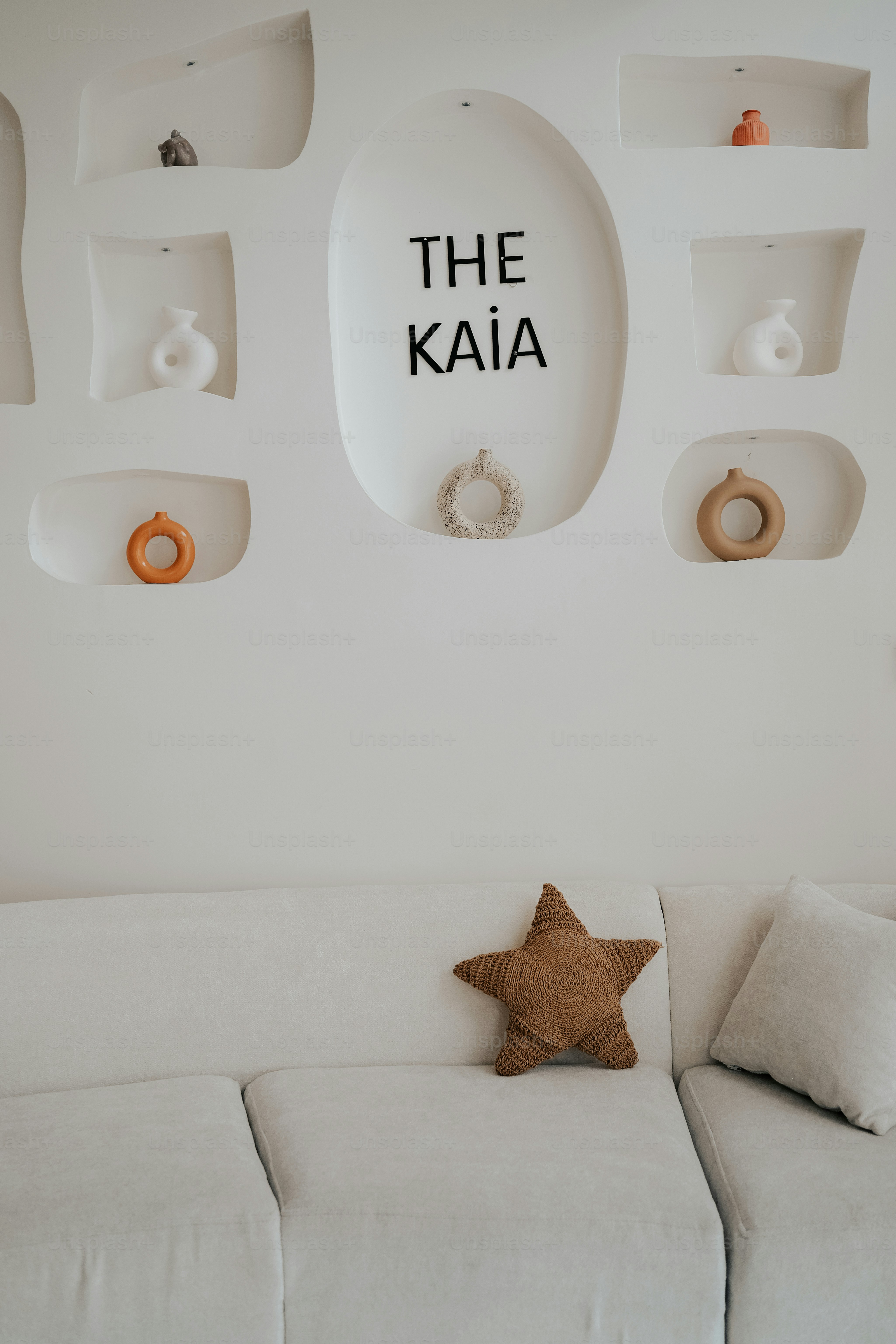 ein Wohnzimmer mit einer weißen Couch und einem sternförmigen Kissen