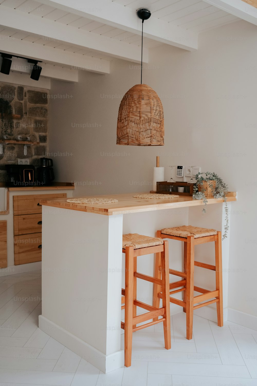 a kitchen with two stools next to a bar