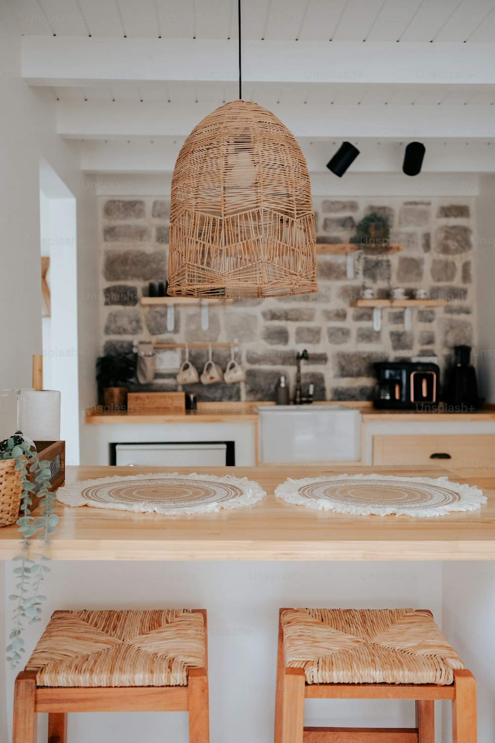 a kitchen with a table, stools and a brick wall